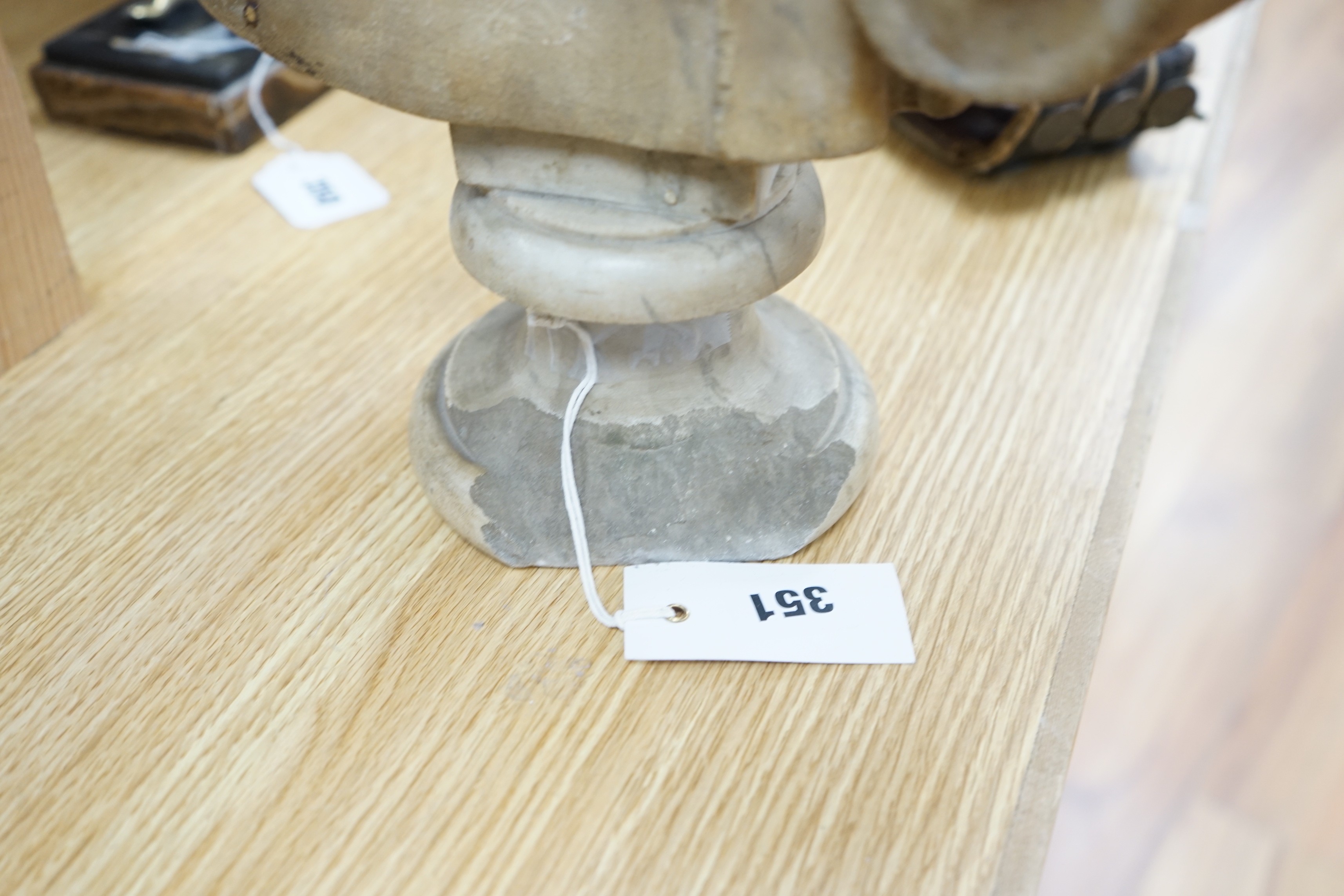 After the Antique marble bust of a Roman man wearing a Chlamys with a buckle at the shoulder, later socle and repairs, 54cm tall